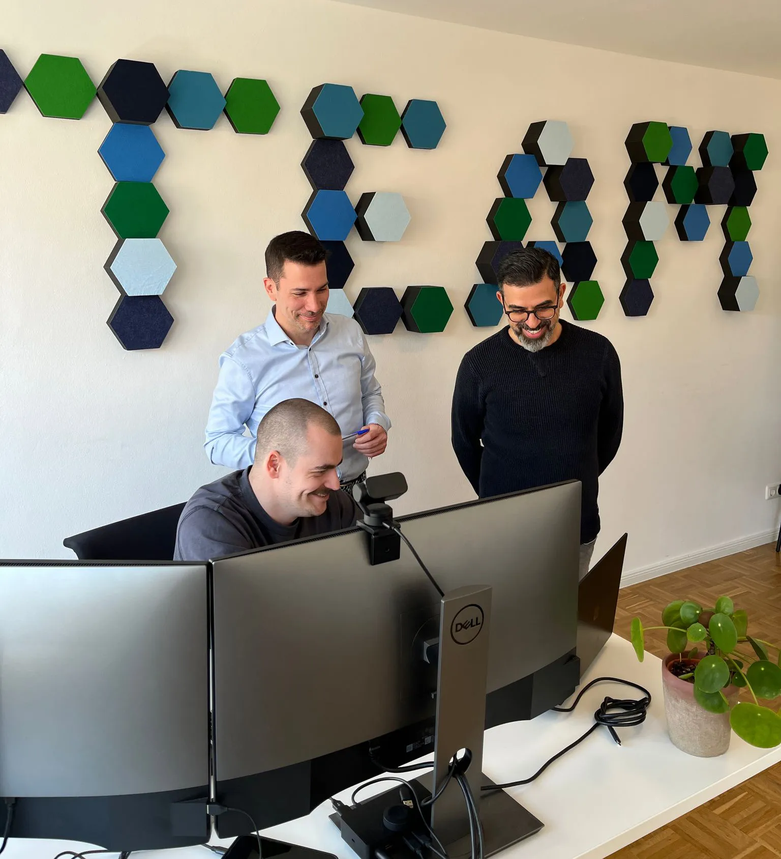 Drei Kollegen von Cloud Dream Team arbeiten gemeinsam an einem Bildschirm.