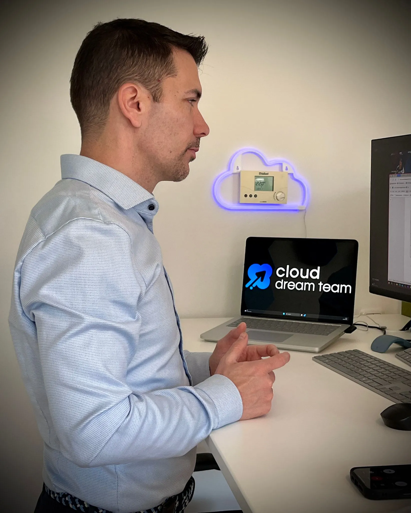 Ein Kollege von Cloud Dream Team am Arbeitsplatz, auf dem Laptop das Logo von Cloud Dream Team.